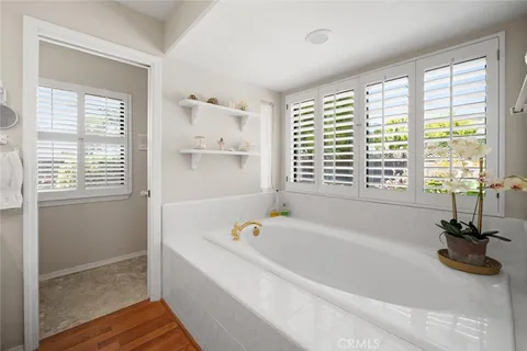a white bath tub sitting in a bathroom next to a window