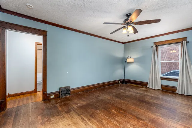 an empty room with closet and a chandelier fan