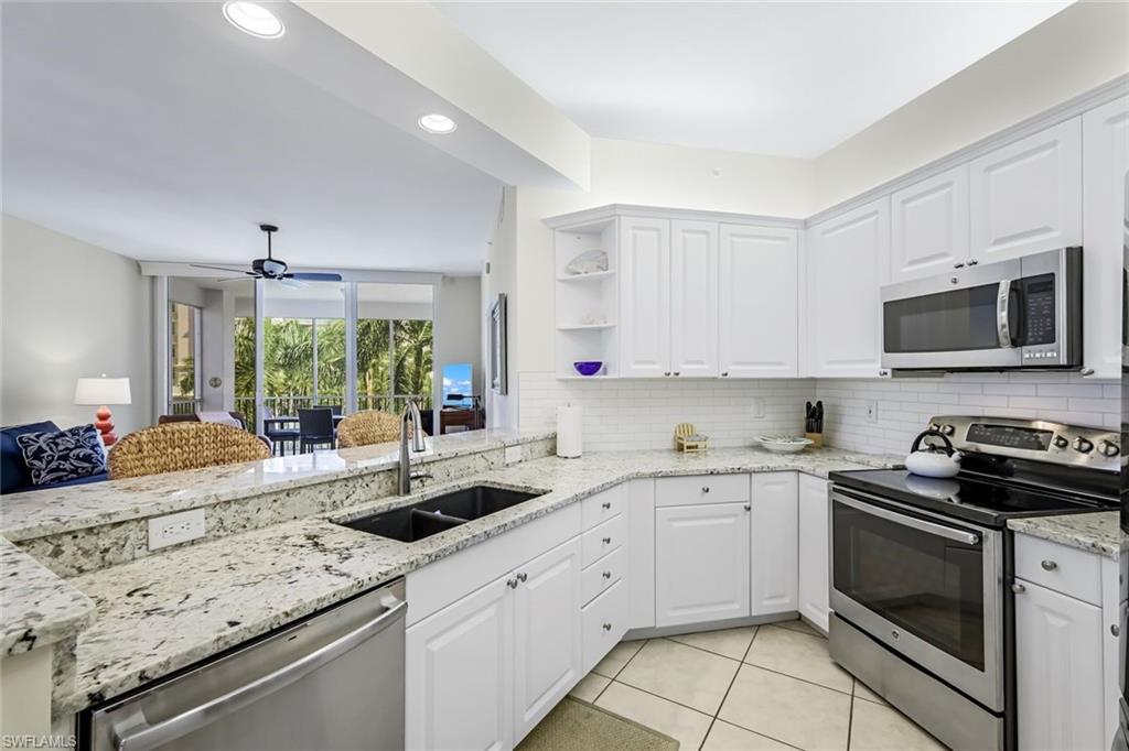 470 Launch Circle, Unit V301 Naples, FL 34108 - Photo 11 of 39 a kitchen with a sink stove top oven and microwave