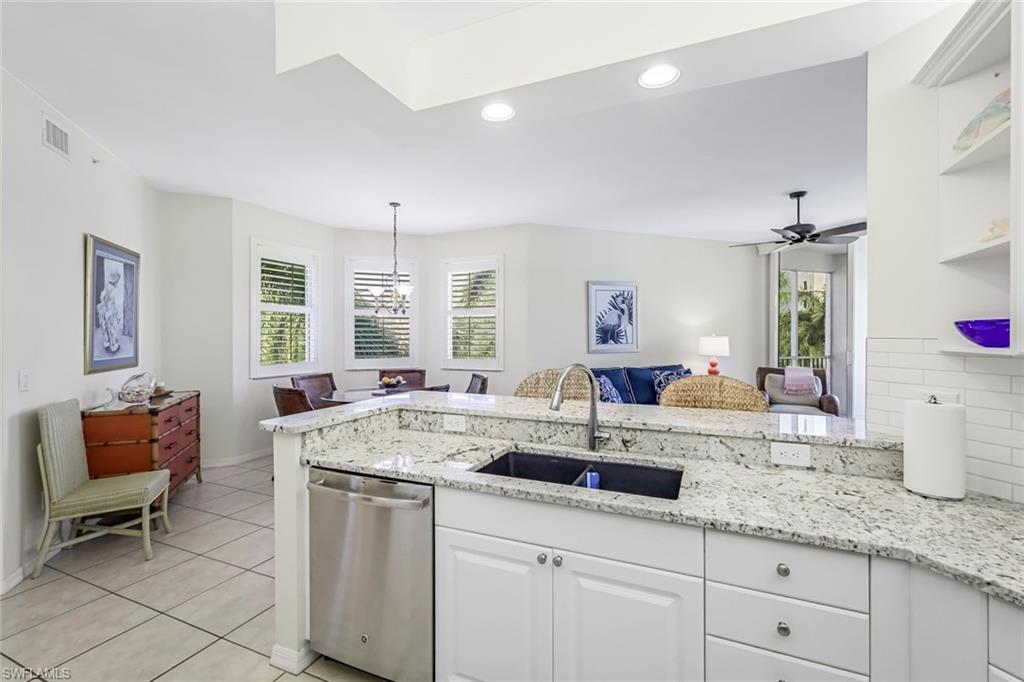 470 Launch Circle, Unit V301 Naples, FL 34108 - Photo 12 of 39 a dining hall with granite countertop a sink dishwasher a dining table and chairs with wooden floor