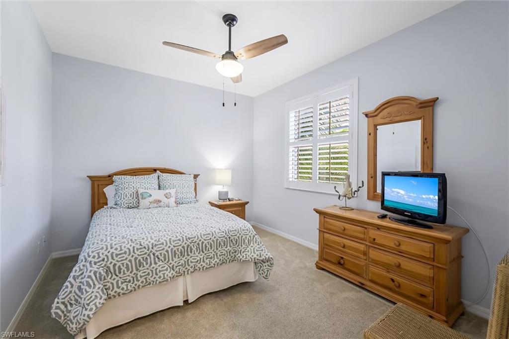 470 Launch Circle, Unit V301 Naples, FL 34108 - Photo 23 of 39 a bedroom with a bed and a tv on the dresser