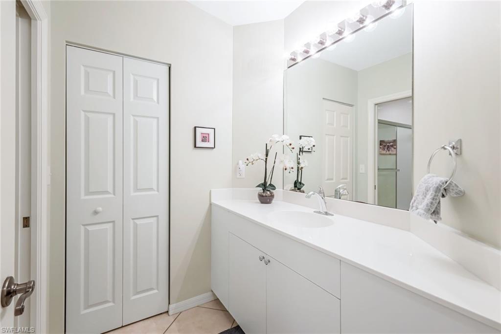 470 Launch Circle, Unit V301 Naples, FL 34108 - Photo 24 of 39 a bathroom with a double vanity sink and a mirror
