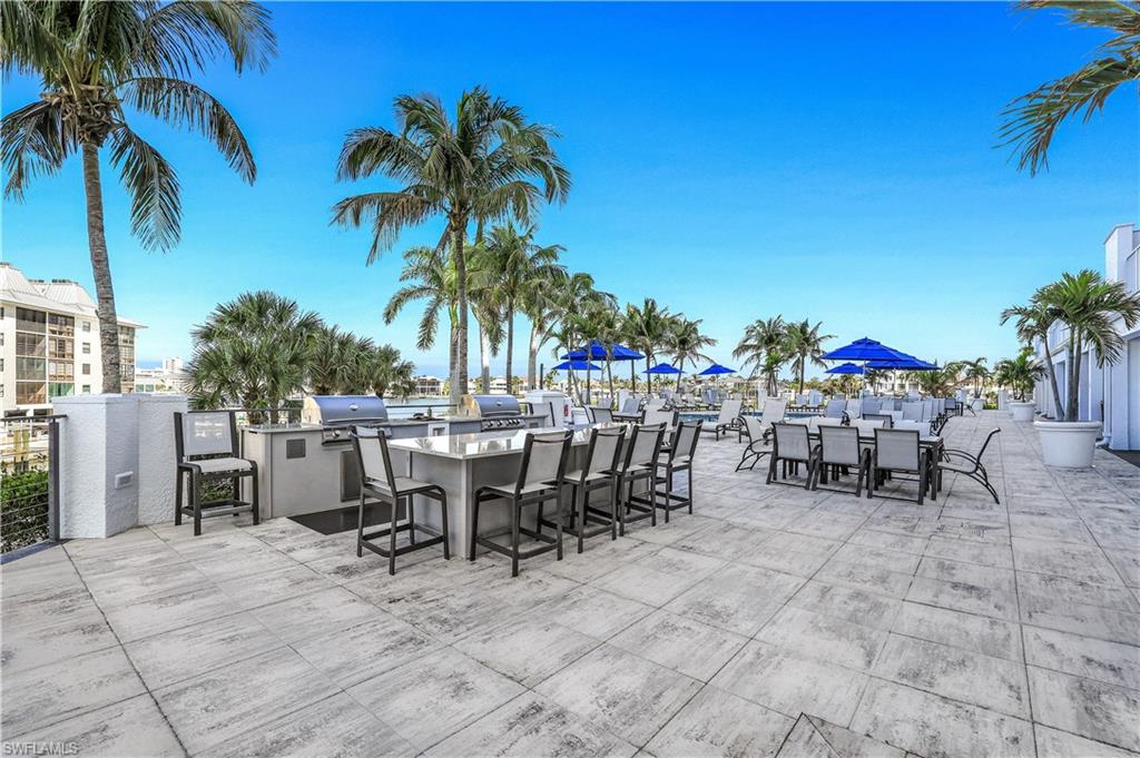 470 Launch Circle, Unit V301 Naples, FL 34108 - Photo 25 of 39 a view of a dining space with furniture and palm tree