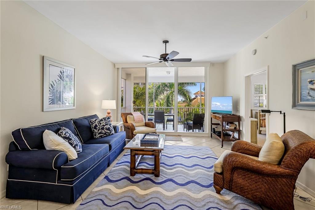 470 Launch Circle, Unit V301 Naples, FL 34108 - Photo 7 of 39 a living room with furniture ceiling fan and a large window