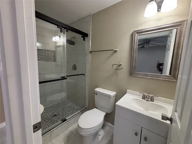 a bathroom with a granite countertop toilet sink and shower