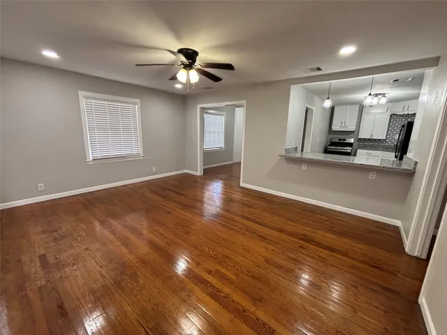 a view of a room with wooden floor and chandelier