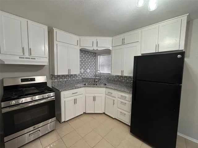 a kitchen with granite countertop cabinets and steel stainless steel appliances