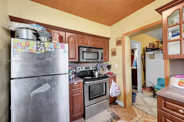 a kitchen with stainless steel appliances a refrigerator and a stove top oven