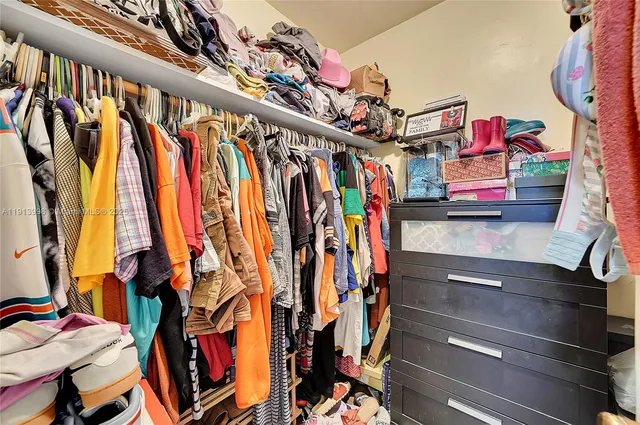 a view of walk in closet with clothes and shoes