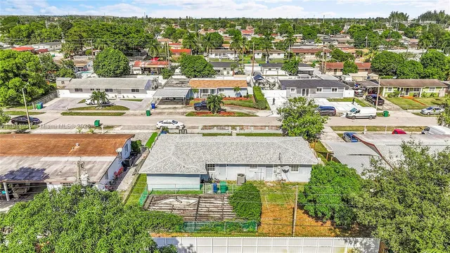 an aerial view of residential houses with outdoor space and street view