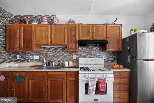 a kitchen with stainless steel appliances granite countertop a sink a stove and a microwave