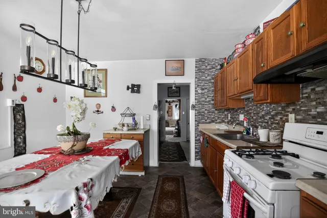 a kitchen with a table chairs stove and refrigerator