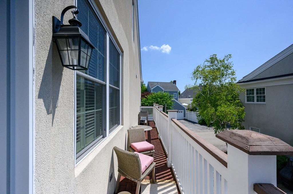 221 Victory Road, Unit 221 Quincy, MA 02171 - Photo 24 of 34 a balcony with wooden floor potted plants and stairs