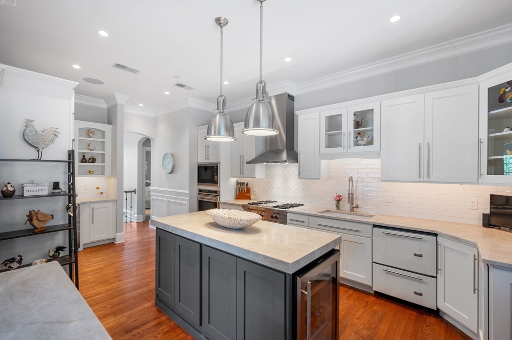 221 Victory Road, Unit 221 Quincy, MA 02171 - Photo 5 of 34 a kitchen with stainless steel appliances kitchen island granite countertop a sink a stove and a wooden floors