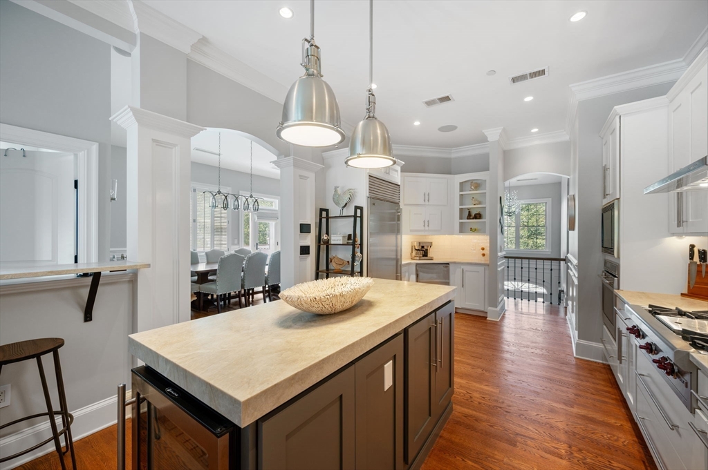221 Victory Road, Unit 221 Quincy, MA 02171 - Photo 8 of 34 a kitchen with stainless steel appliances kitchen island granite countertop a table chairs and a refrigerator