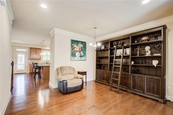 a kitchen with stainless steel appliances granite countertop a stove a refrigerator a kitchen island a dining table and chairs with wooden floor