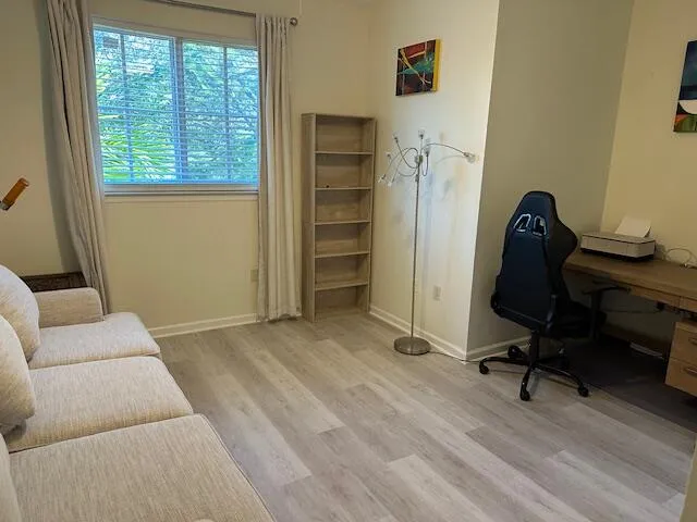 a view of a livingroom with workspace and a window