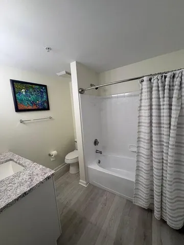 a bathroom with a granite countertop sink toilet and shower