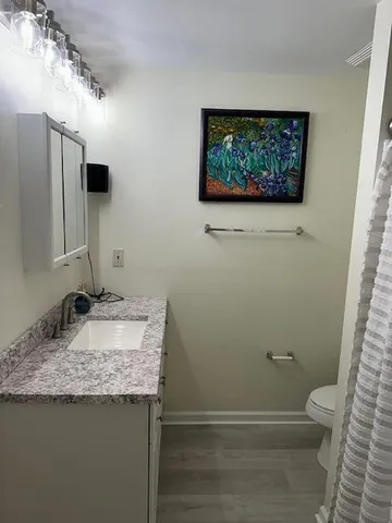 a bathroom with a granite countertop sink and a mirror