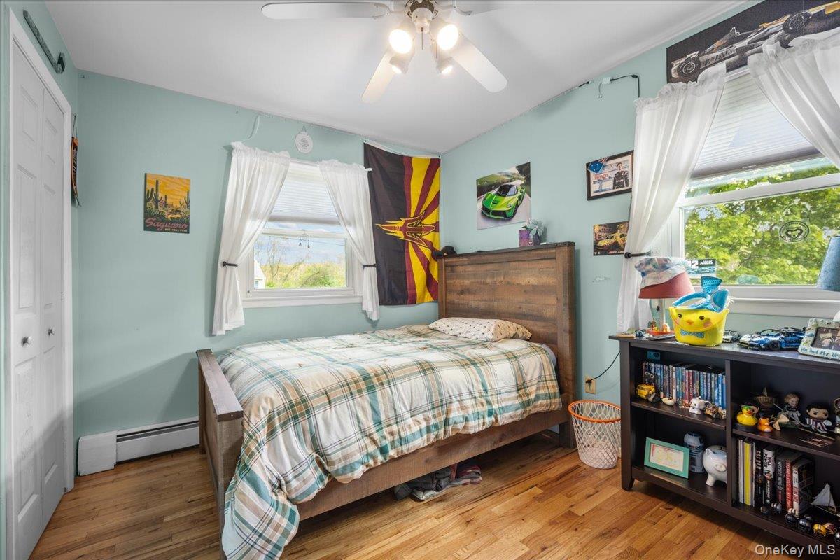 10 Richard Road Mahopac, NY 10541 - Photo 15 of 33 Bedroom featuring a closet, light wood finished floors, a baseboard heating unit, and ceiling fan