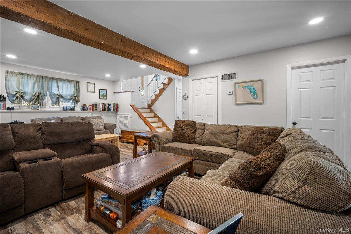 10 Richard Road Mahopac, NY 10541 - Photo 19 of 33 Living room featuring beam ceiling, recessed lighting, wood finished floors, and stairway