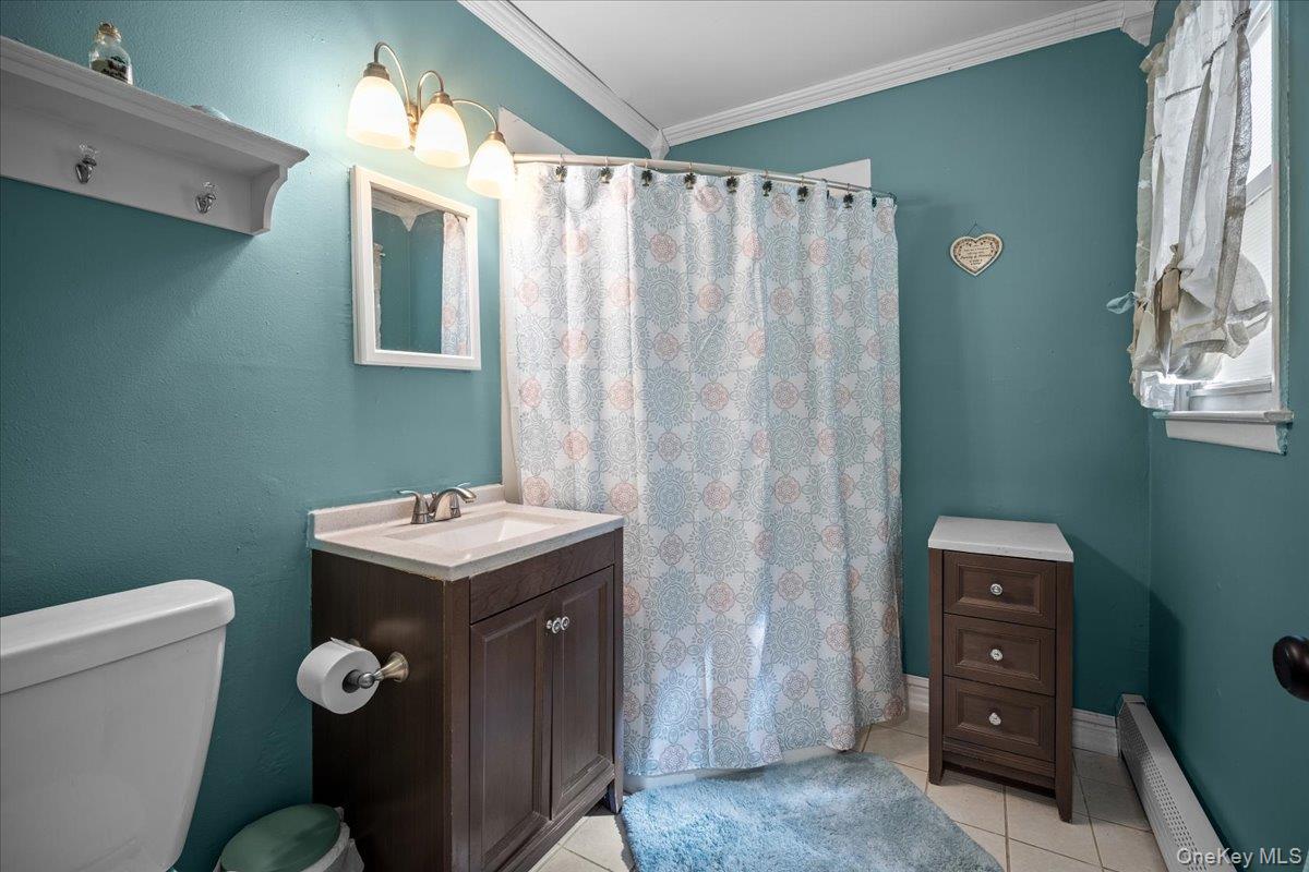 10 Richard Road Mahopac, NY 10541 - Photo 22 of 33 Bathroom with a baseboard heating unit, curtained shower, crown molding, vanity, and light tile patterned flooring