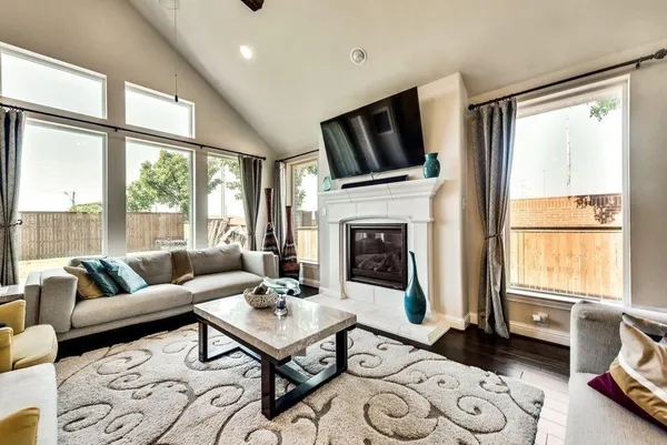 a living room with furniture fireplace and a large window