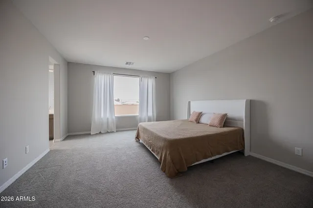 a spacious bedroom with a bed and a window