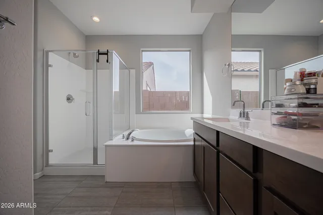 a bathroom with a bathtub a double vanity sink and mirror