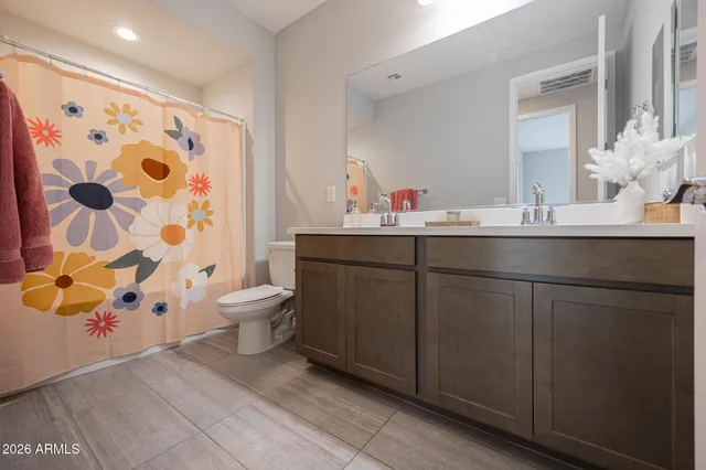 a bathroom with a sink and mirror with toilet