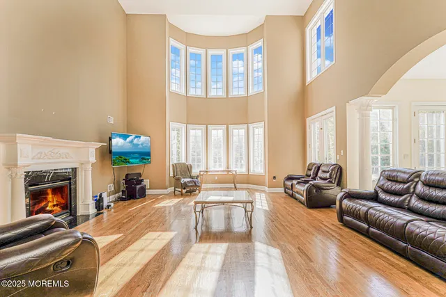 a living room with furniture fireplace and a large window