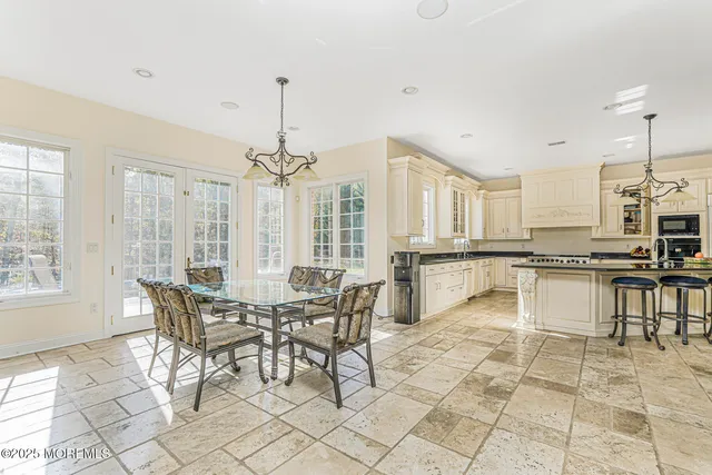a large kitchen with kitchen island a sink table and chairs