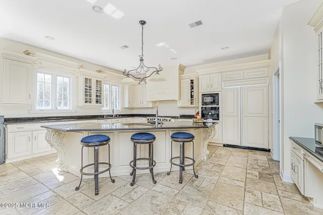 a large kitchen with granite countertop white cabinets and a sink