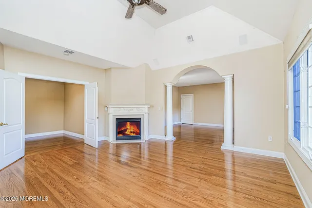 wooden floor fireplace and windows in an empty room