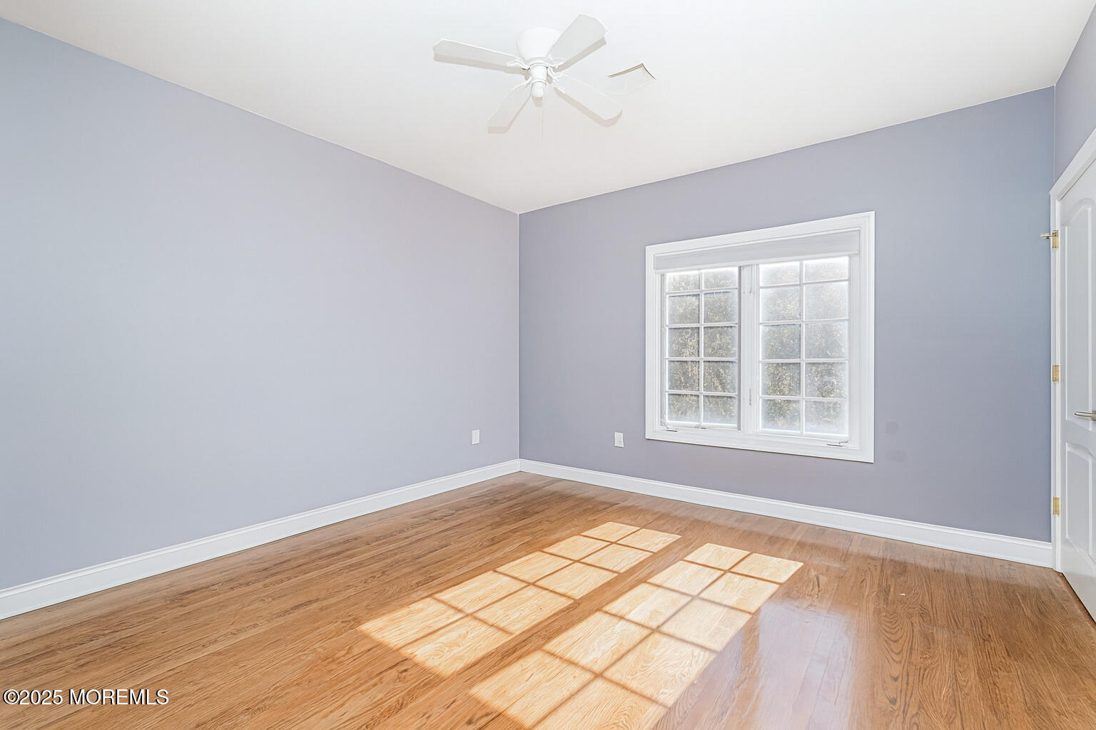 97 Stone Hill Road Colts Neck, NJ 07722 - Photo 41 of 51 an empty room with wooden floor chandelier fan and windows