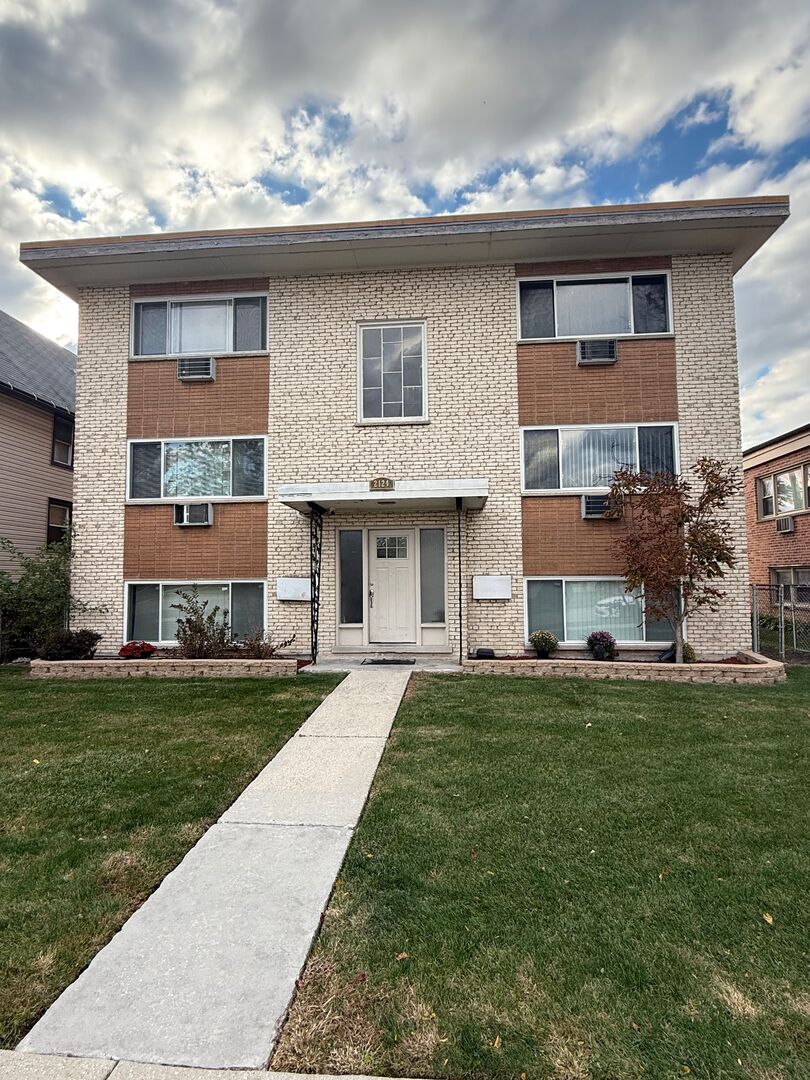 2124 14th Avenue, Unit 1S Broadview, IL 60155 - Photo 1 of 7 a front view of a house with a garden and plants