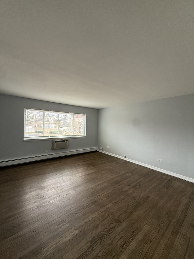 2124 14th Avenue, Unit 1S Broadview, IL 60155 - Photo 3 of 7 a view of an empty room with wooden floor and a window