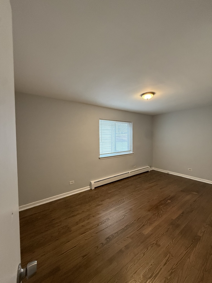 2124 14th Avenue, Unit 1S Broadview, IL 60155 - Photo 6 of 7 an empty room with wooden floor and windows