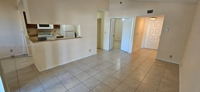 a kitchen with white cabinets and refrigerator