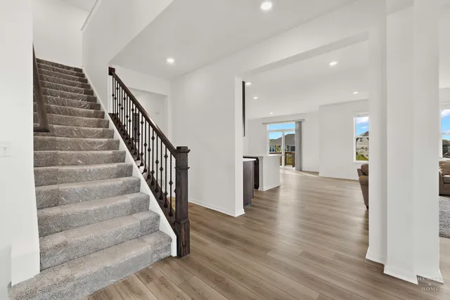 a view of a hallway with wooden floor and stairs