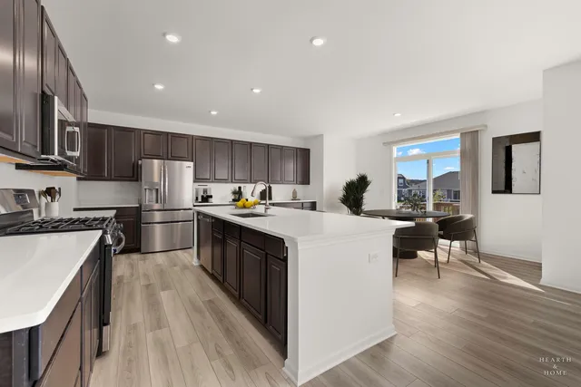 a kitchen with a sink a counter top space stainless steel appliances and a center island