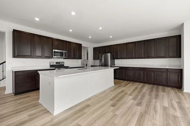 a large kitchen with cabinets stainless steel appliances and a counter space