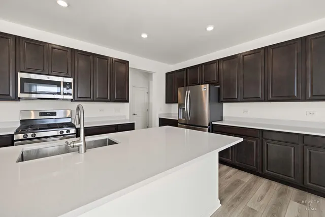 a kitchen with stainless steel appliances wooden cabinets a refrigerator and a stove
