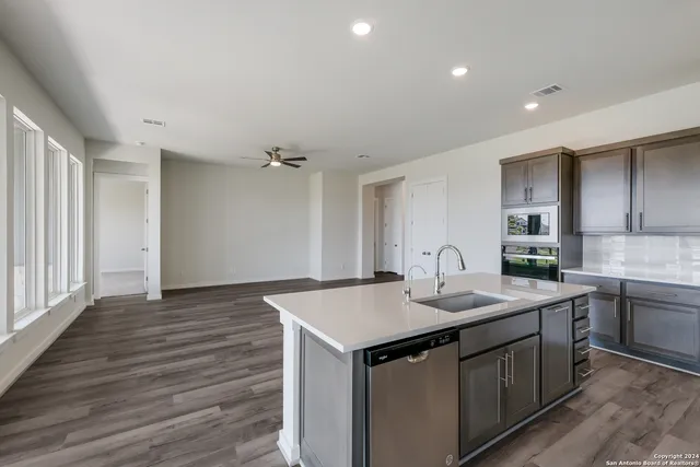 a kitchen with a sink cabinets and wooden floor