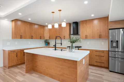 a kitchen with stainless steel appliances granite countertop a sink a refrigerator and a stove