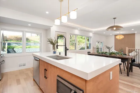 a kitchen with a stove a refrigerator a sink and a large window