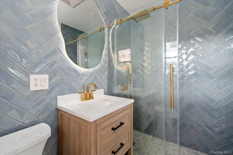 a bathroom with a sink a mirror and shower