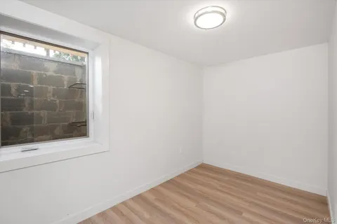 a view of a small space with wooden floor and mirror