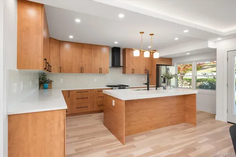 a kitchen with stainless steel appliances granite countertop a sink a stove and a wooden floors