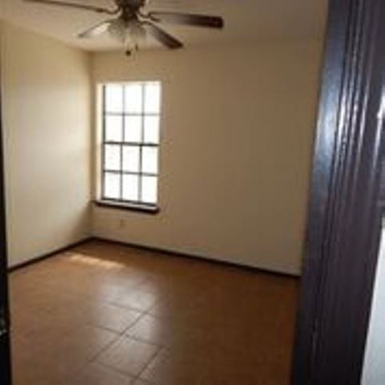 3202 Chacota Street Laredo, TX 78046 - Photo 8 of 11 an empty room with a window and a chandelier fan